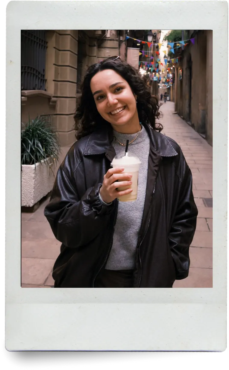 Isa holding a milkshake in a narrow street, printed as an instant photo